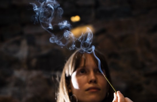 A woman holding a burning incense