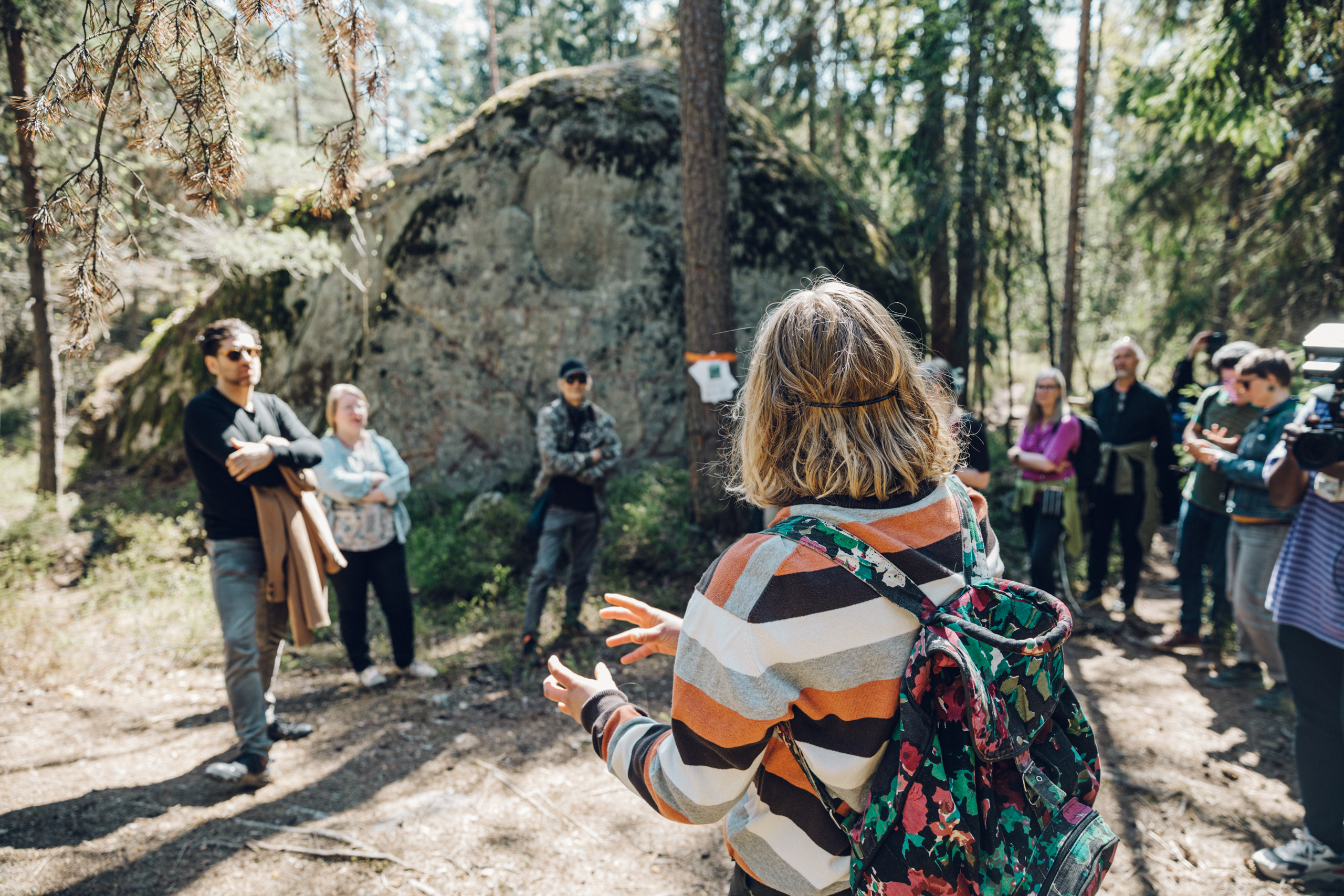 A group of people nearby a big rock in Stansvik forest.