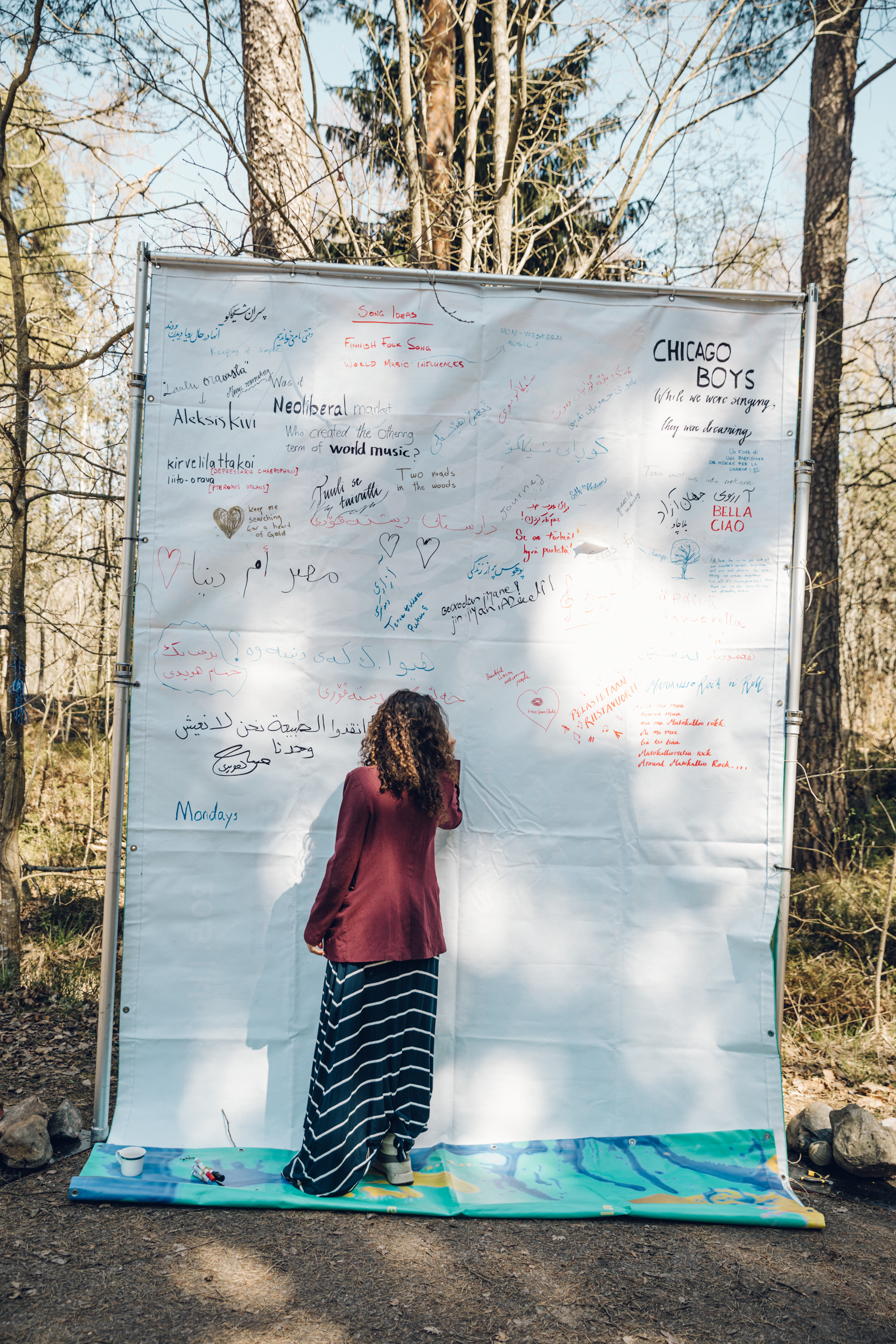 A person writing on a big canvas in Chicago Boys public rehearsals in Stansvik Village.