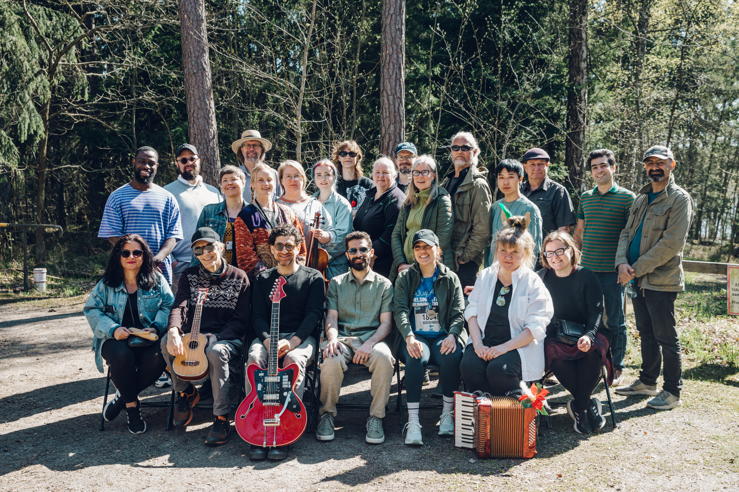 A group photo of smiling people with music instruments in Stansvik village.