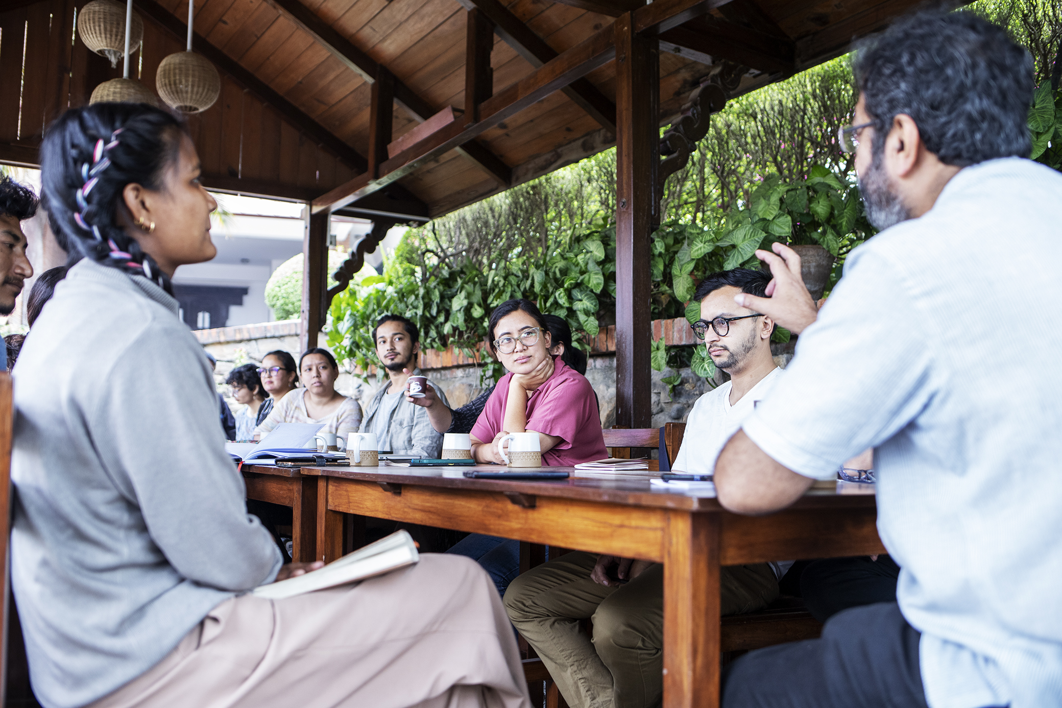 A group of people around a table discussing at Learning from Doubt course in Nepal.