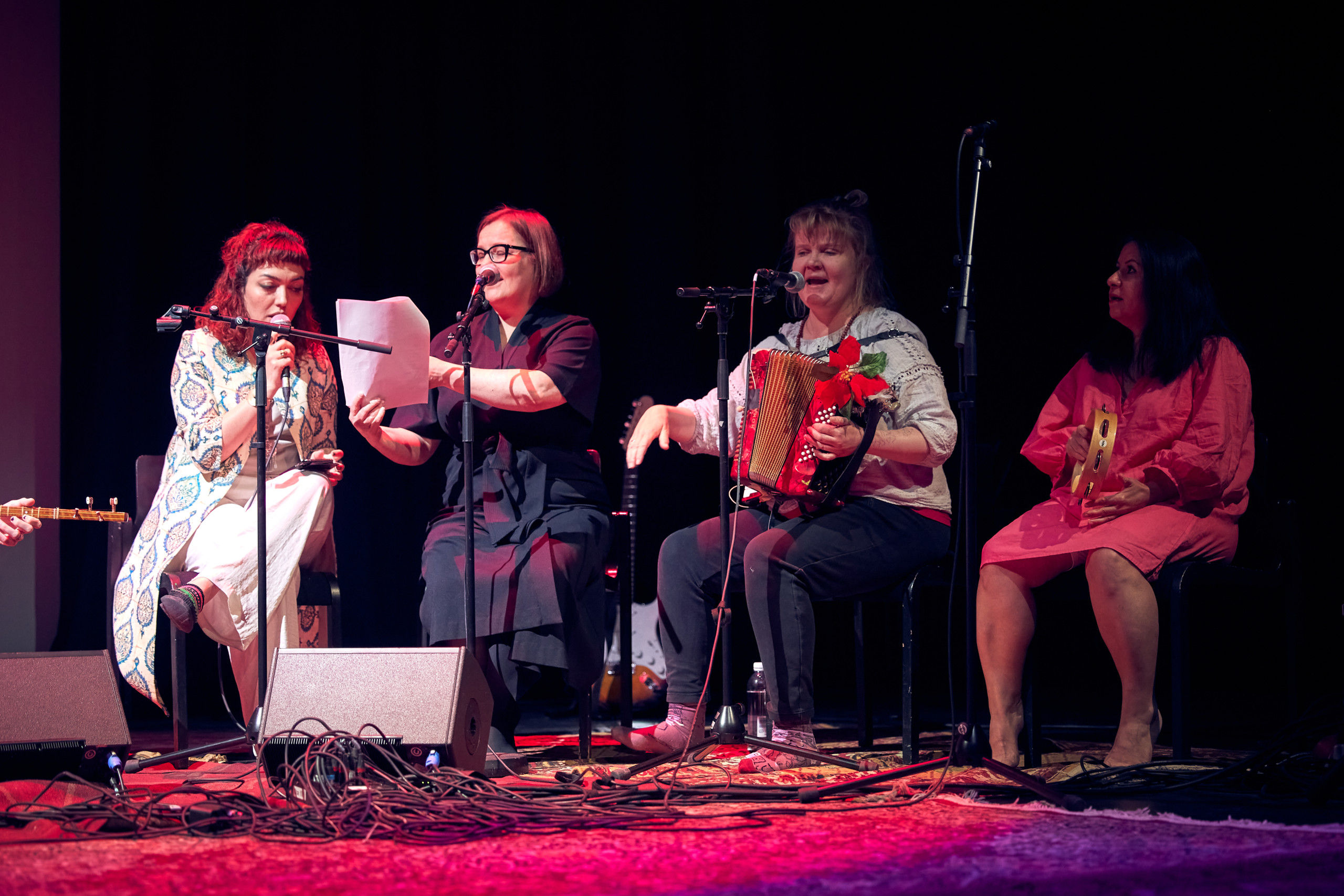 Four persons singing and playing together.