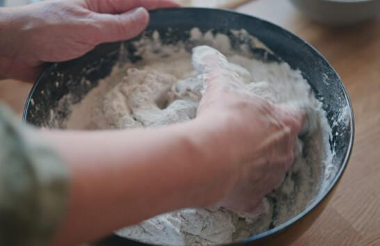 Image about hands mixing a bread dough in a bowl.