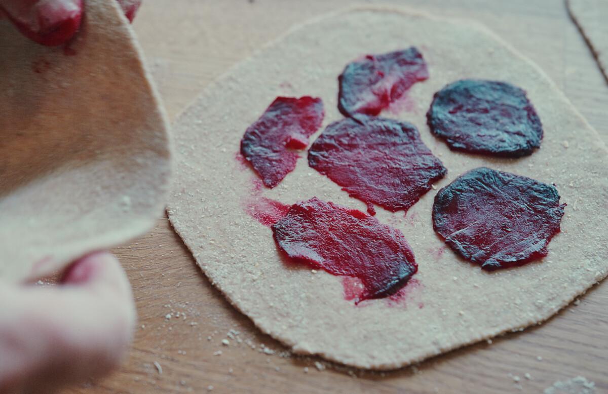 Image of bread dough with slices of beetroot on top of it.