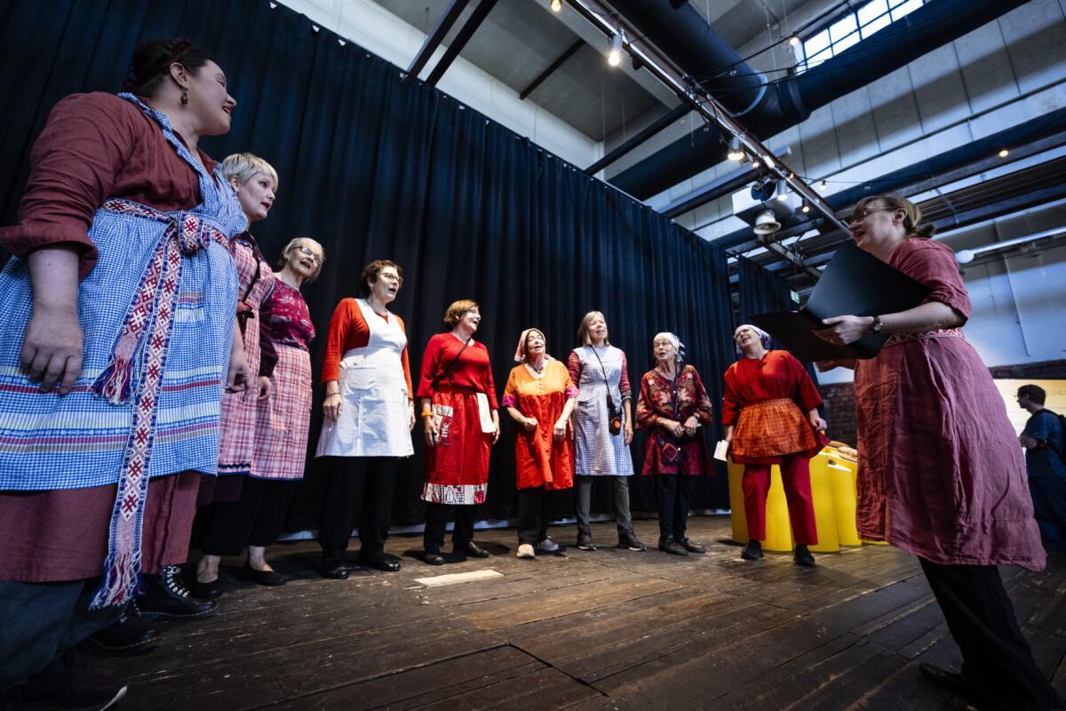 A group of women of different ages sing in a choir.