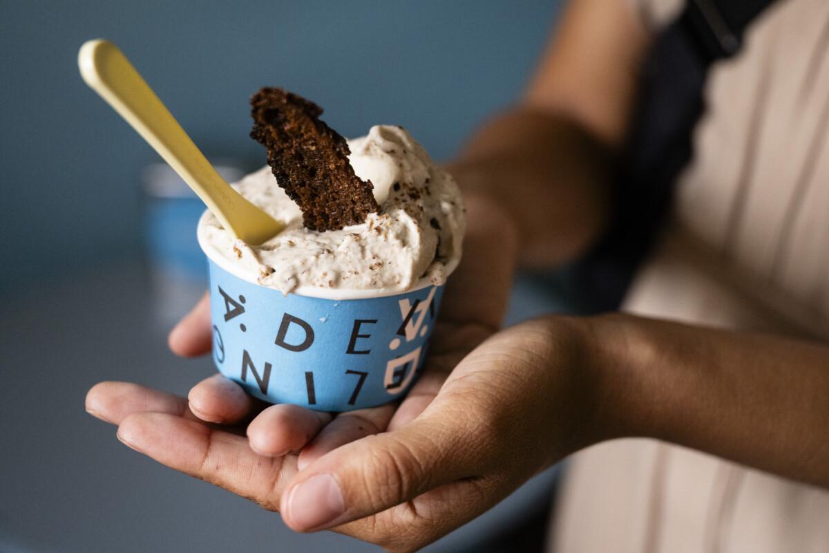 The picture shows ice cream in a cup with a piece of bread standing upright.