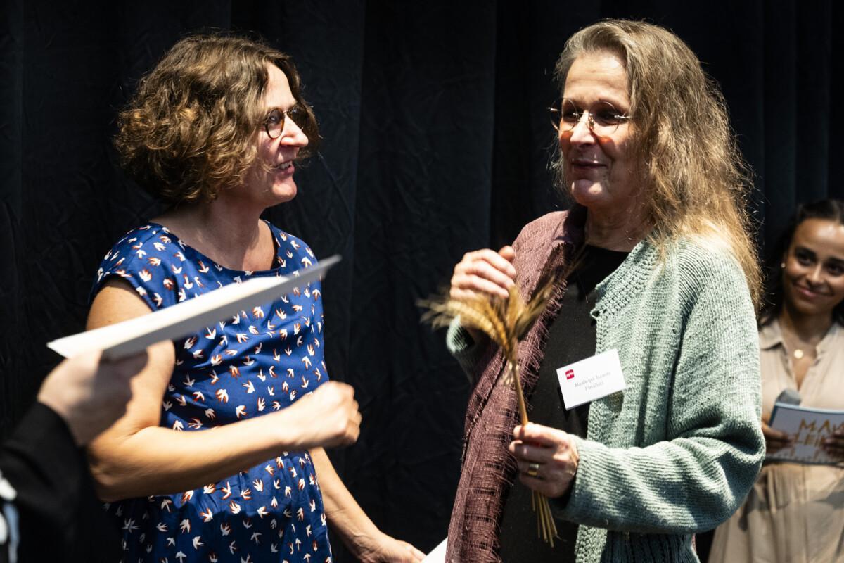 The picture shows two women smiling happily.