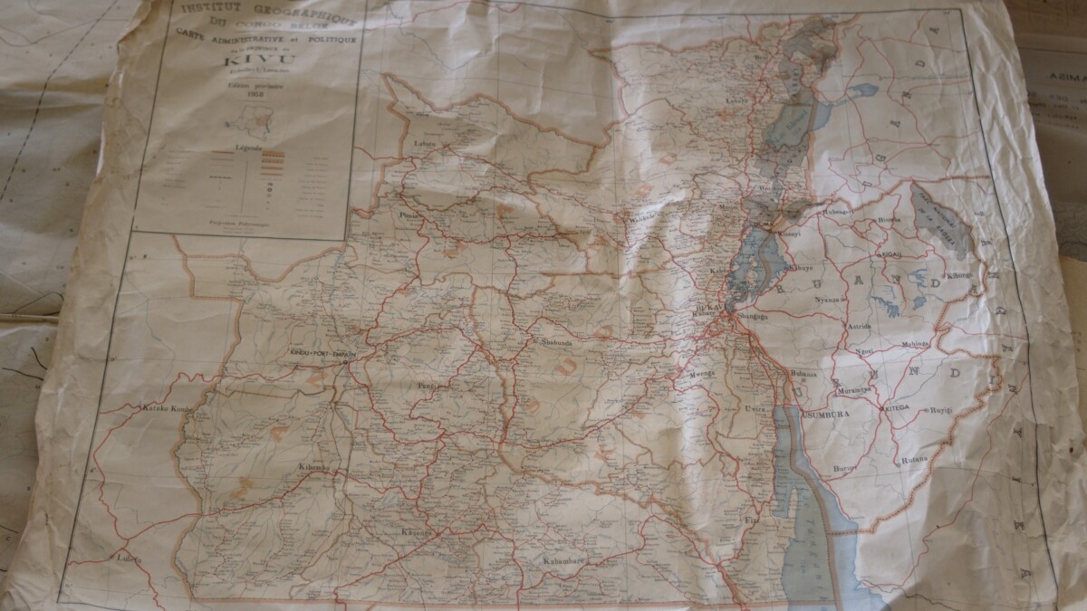 The picture shows an old crumpled Belgian colonial map of the Congo.